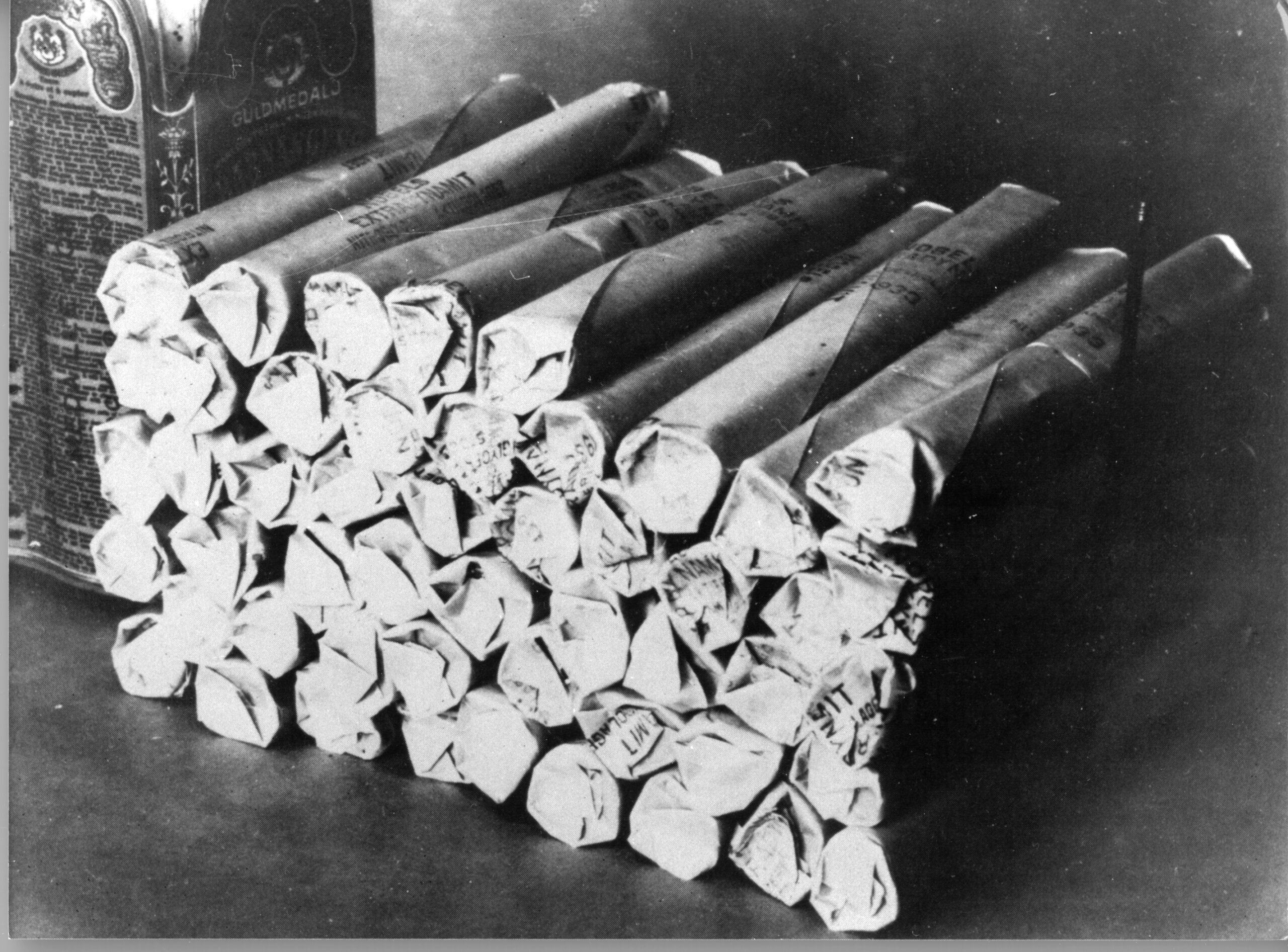 A black-and-white photo of a pile of dynamite, the most famous invention of Alfred Nobel.