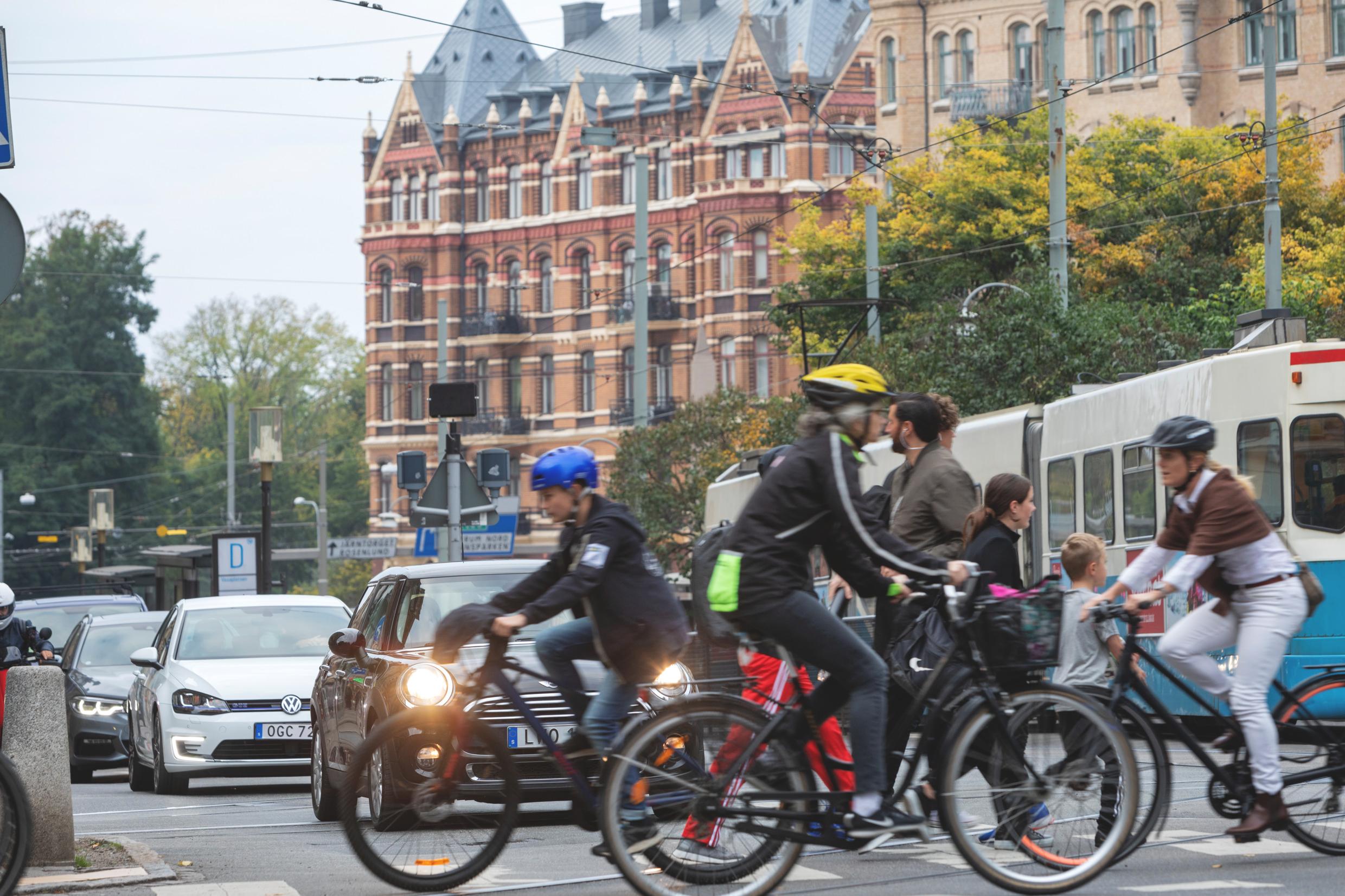 A traffic crossing with cars, bikes and pedestrians.