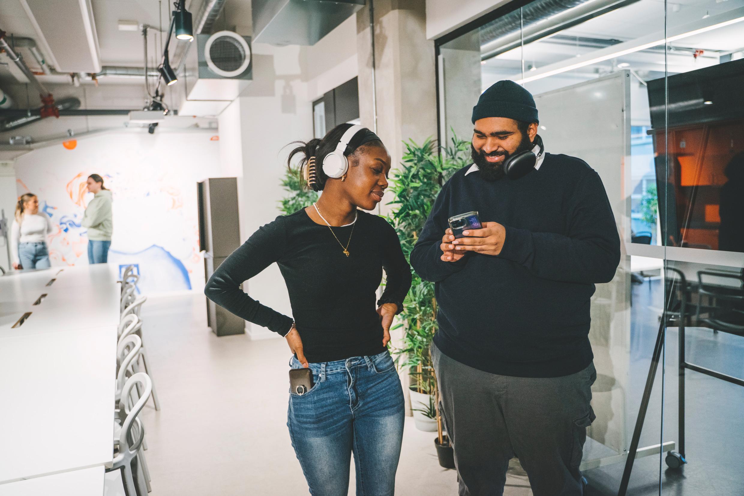 People using mobile phones in a modern work environment in Sweden.